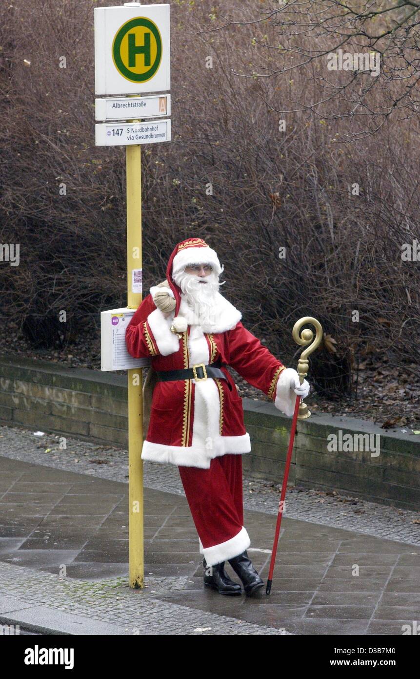 (Dpa) - lehnt Santa Claus auf einem Bus Stop-Schild, Berlin, 17. Dezember 2002. Ohne Schnee ist ein Bus praktischer als ein Schlitten. Stockfoto
