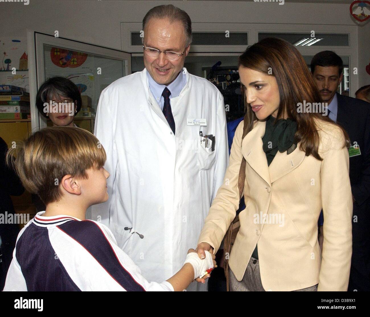 (Dpa) - Königin Rania von Jordanien wird von Maximilian begrüßt, ein Patient in der Kinderklinik Charite Campus Virchow in Berlin, 23. Oktober 2002, während der Klinik-Direktor Gerhard Gaedicke blickt auf. Königin Rania und ihre Familie sind auf einer dreitägigen Staatsbesuch in Deutschland. Stockfoto