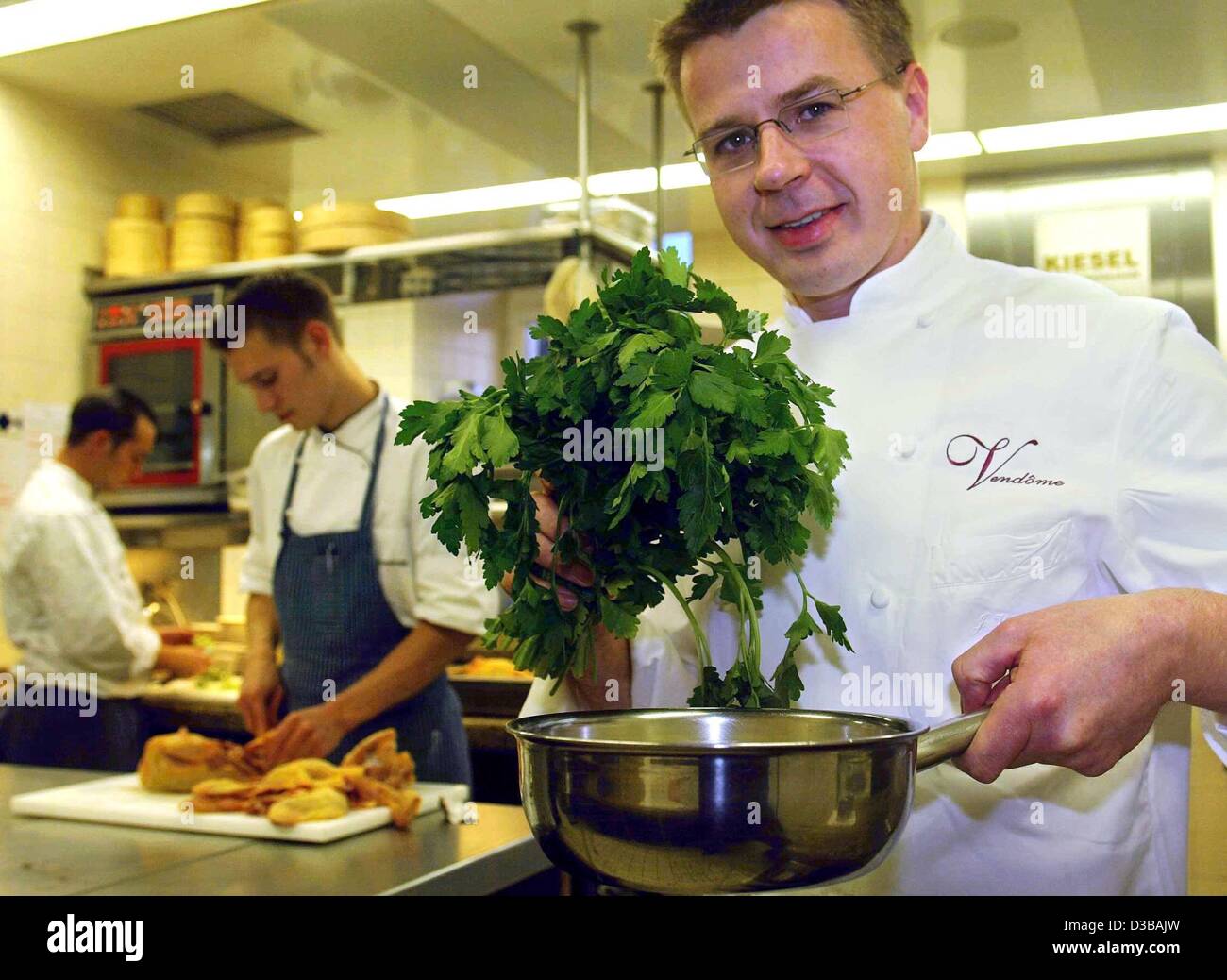 (Dpa) - Joachim Wissler, Koch des Jahres 2003 von der Restaurantführer Gault Millau, posiert mit einem Topf und einem Bund Petersilie in der Küche von seinem Restaurant Vendôme im Hotel Schloss Bensberg in Bergisch, Deutschland, 20. November 2002. Stockfoto