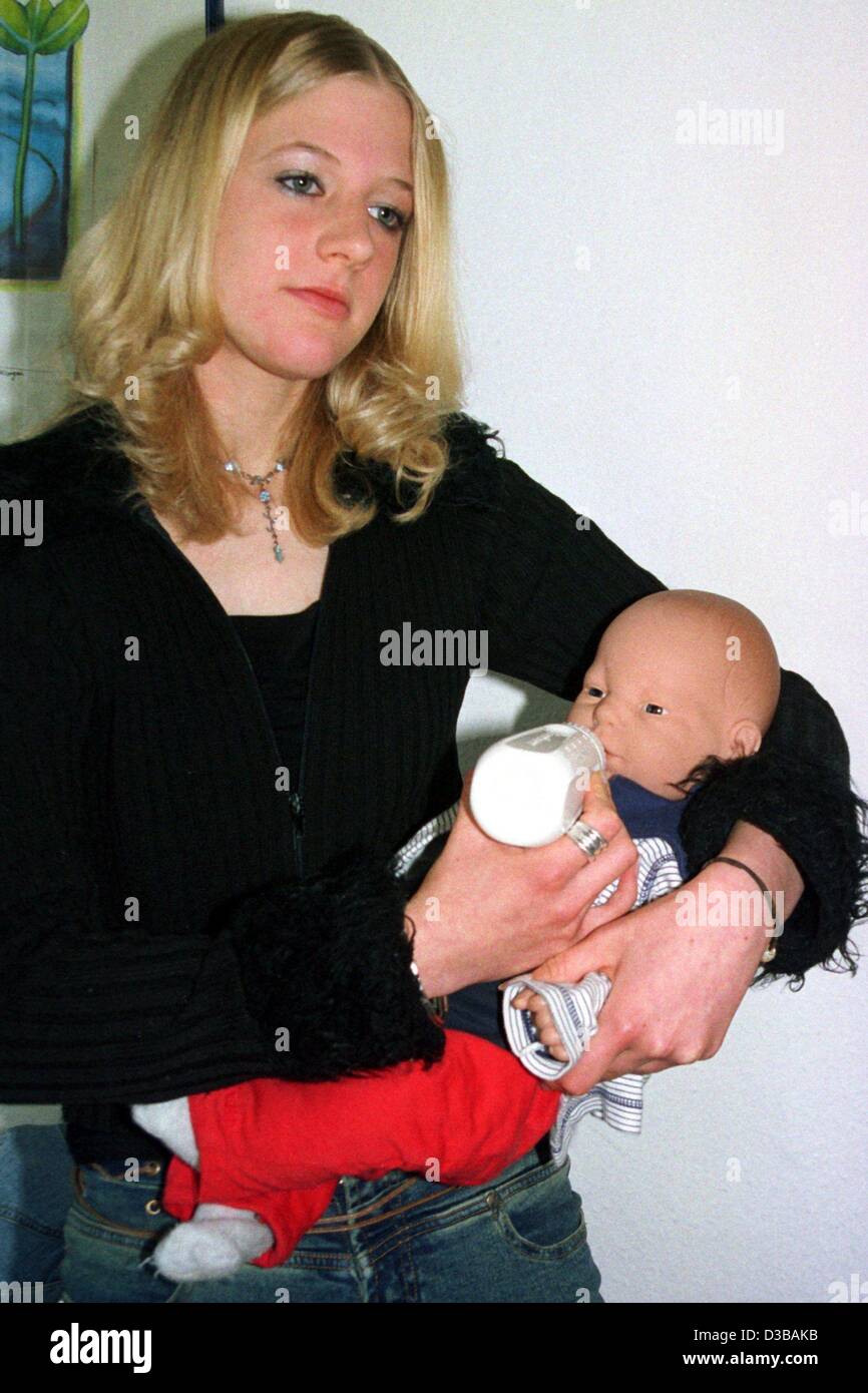 (Dpa) - 15-jährige Anna-Lena Giese Simulator Baby "Julian" mit einer Flasche, Lingen, Deutschland, 9. Oktober 2002 füttert. Sie praktiziert Mutterschaft mit dem True-to-Life-Simulator für drei Tage. "Julian" ist Teil des Programms "Eltern auf Bewährung" macht zu sehen, dass Jugendliche eine eigene Chil Stockfoto