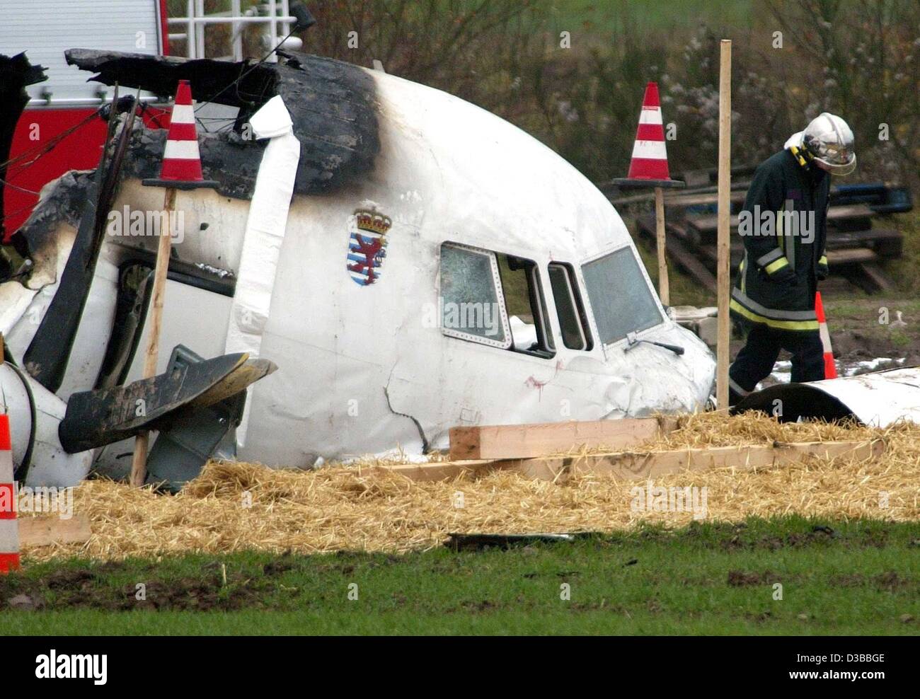 (Dpa) - steht ein Retter neben dem Wrack der Luxair Fokker 50 die nahe Niederanven, Luxemburg, 6. November 2002 stürzte. 17 Menschen starben, fünf sind schwer verletzt. Das Flugzeug kam aus Berlin und stürzte Flughafen Findel im dichten Nebel nähert. Das Luftfahrtunternehmen angekündigt, dass 1 Stockfoto