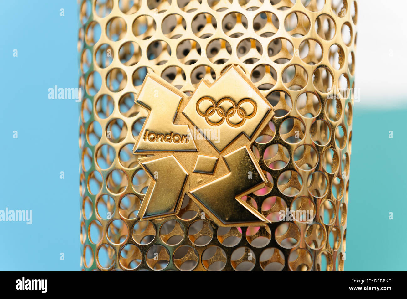 Olympische Fackel in der Nähe der Anzeige mit Logo der Olympischen Spiele 2012 in London Stockfoto