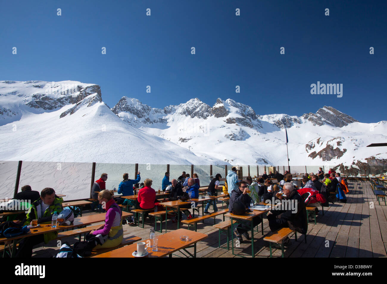 Skifahrer mit Mittagessen auf der Terrasse des Bergrestaurant über Zürs, Arlberg, Österreich. Stockfoto