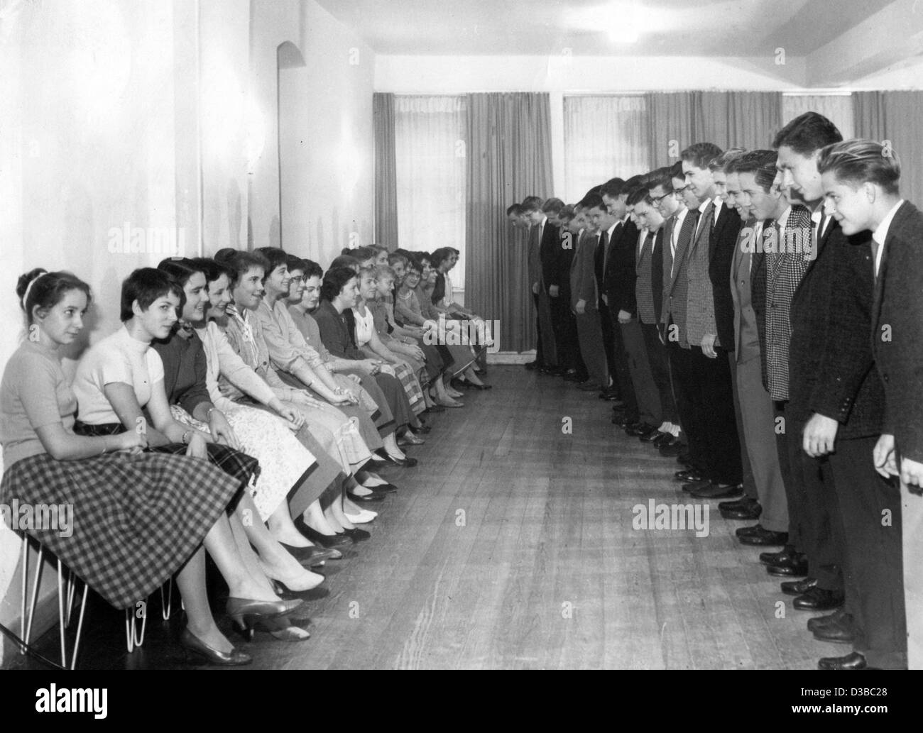 (Dpa-Dateien) - jungen Mädchen zu treffen: die jungen Herren lernen, eine Verbeugung vor Fragen eines der jungen Damen zum Tanz, in einer Tanzschule in Kaiserslautern, Deutschland, 20. November 1958 zu übernehmen. Stockfoto
