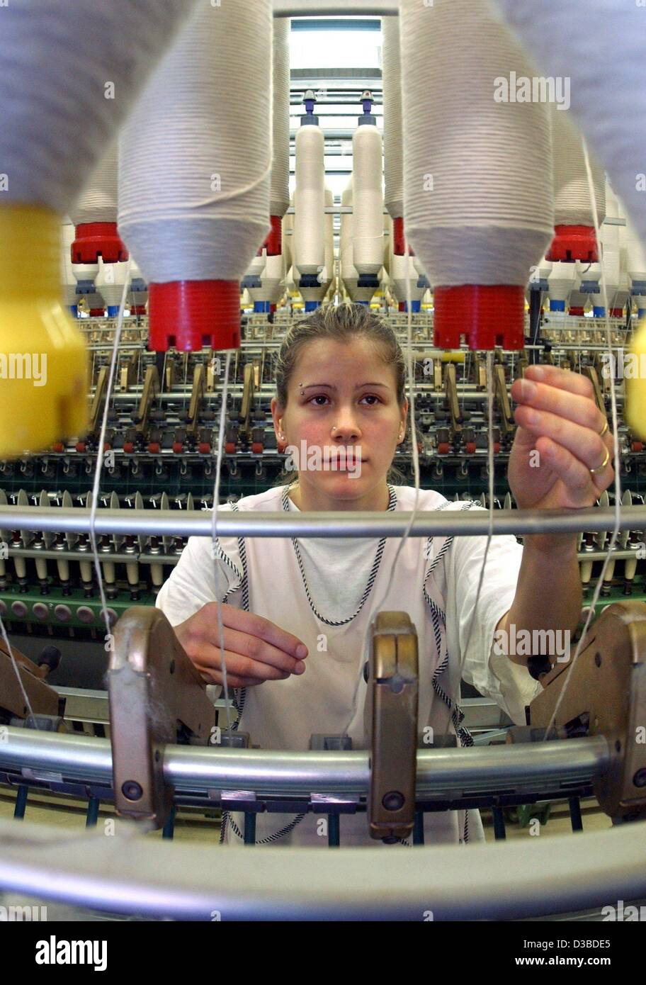 (Dpa) - Anja Melzer betreibt eine Ringspinnmaschine produzieren feine gekämmten Baumwolle in Hohenfichte, Deutschland, 22. Januar 2003. Die Saechsische Baumwollspinnerei GmbH produziert 20.000 Tonnen Garn pro Jahr, beschäftigt 370 Mitarbeiter und erzielt einen Jahresumsatz von rund 37 Millionen Euro. Stockfoto