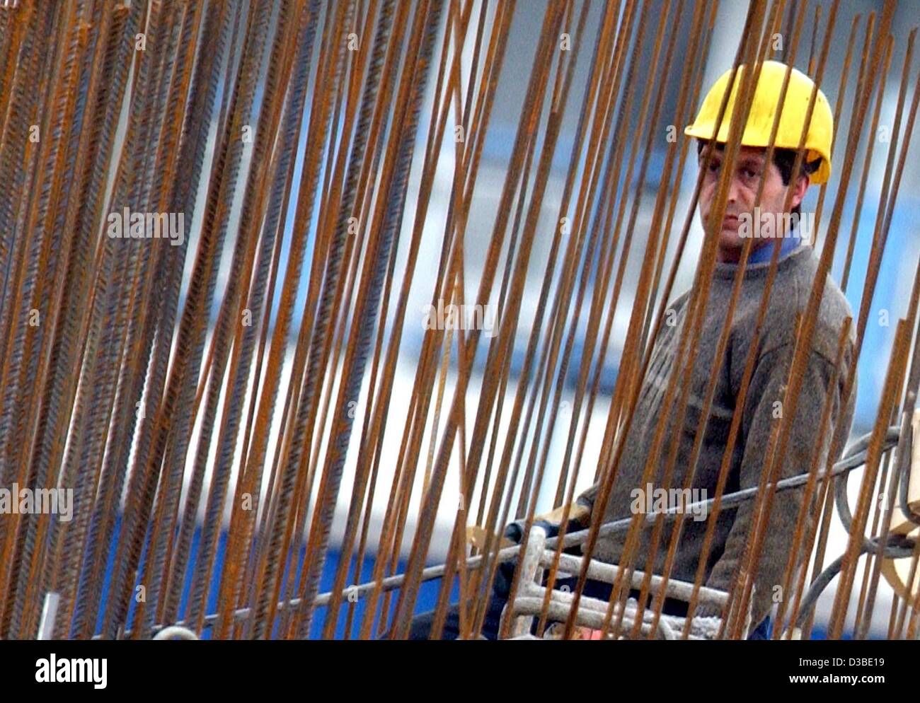 (Dpa) - ein Arbeiter steht hinter einer Reihe von Stahl streben auf einer Baustelle in Frankfurt am Main, 22. Januar 2003. Die IG BAU (Industriegewerkschaft für Gebäude, Landwirtschaft und Umwelt) plant eine Demonstration in mehreren deutschen Städten am 24 Januar, politische Veränderungen der Nachfrage. Aktuelle Politik des l Stockfoto