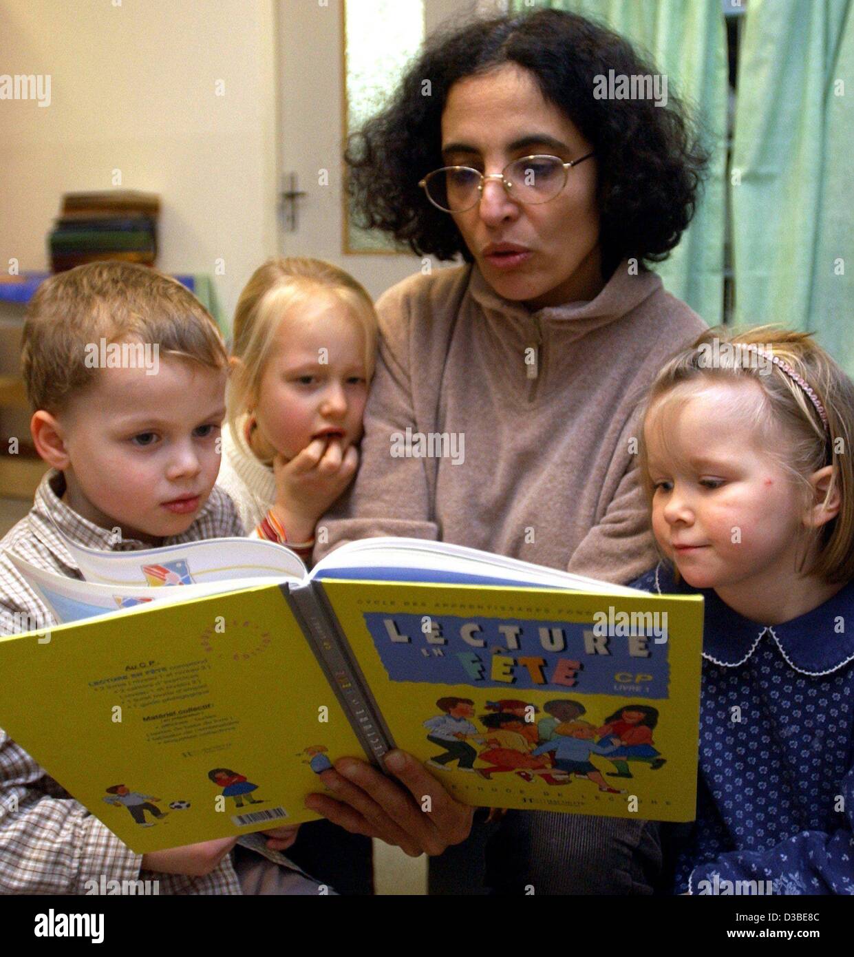 (Dpa) - französischer Tag Pflegedienst Nora Ennulat liest ein Kinderbuch der französischen Sprache für Kinder in der "Au Clair De La Lune" (Mond Glanz) Tagesstätte in Magdeburg, Deutschland, 11. Dezember 2002. Die erste Deutsch-französische Kindergarten unterrichtet Französisch auf spielerische Weise. Das Ziel dieser Institution ist nicht Stockfoto