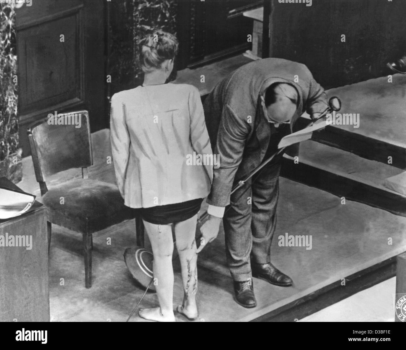 (Dpa-Dateien) - Zeuge J. Bzize aus Polen zeigt die Narben am rechten Bein, die das Ergebnis der medizinischen Experimente waren, wenn sie im Konzentrationslager Ravensbrück, im Bild während der "Ärzte-Studie" der Nürnberger Prozesse am Hof in Nürnberg, Deutschland, 22. Dezember 1946 inhaftiert war. Stockfoto