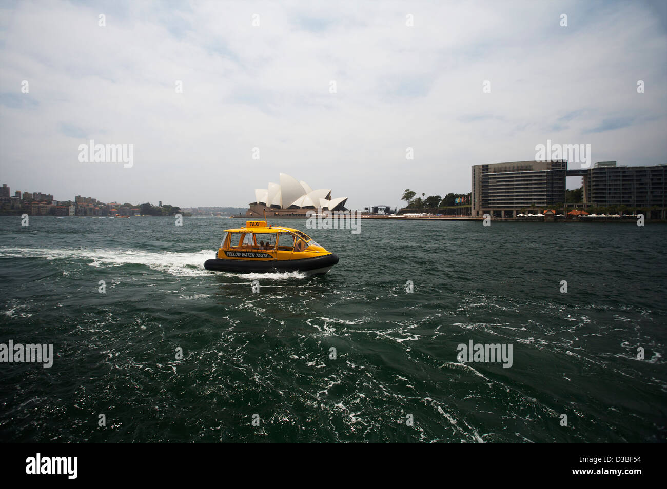 Gelben Taxis nähert sich kreisförmige Taste mit der Oper von Sydney im Hintergrund, Sydney, Australien Stockfoto