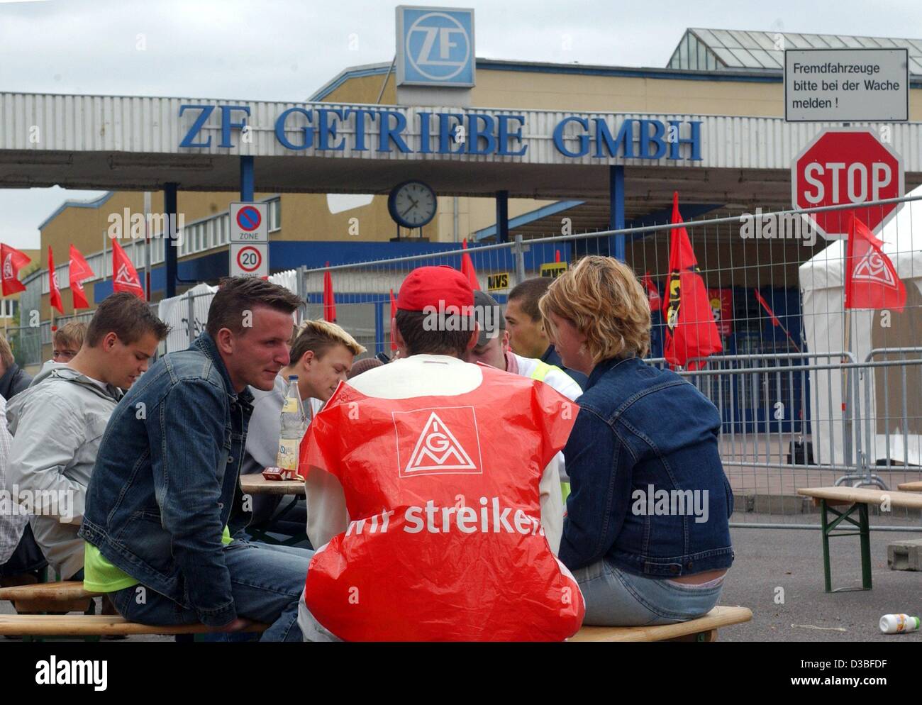 (Dpa) - Arbeiter und Streikposten sitzen an einem Tisch außerhalb der Firma ZF Getriebe GmbH in Brandenburg an der Havel, Deutschland, 25. Juni 2003. Der Metall Gewerkschaft IG Metall hat rund 9.500 Mitarbeiter in Berlin, Brandenburg und Sachsen zu streiken für ihren Bedarf an die 35-Stunden-wee gebeten. Stockfoto