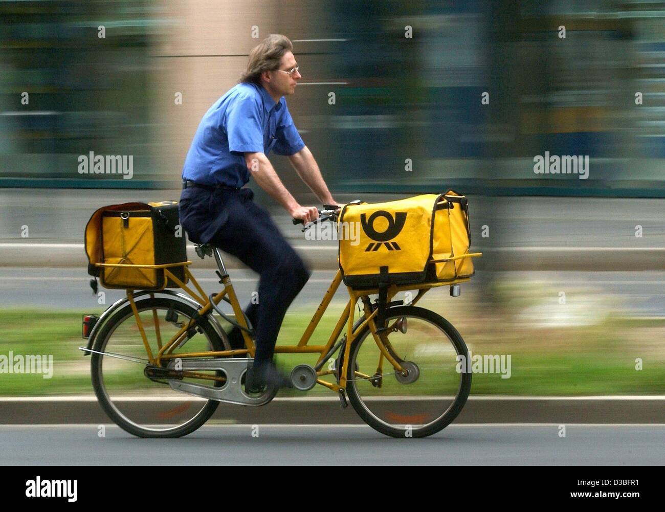 (Dpa) - stürzt ein Briefträger auf dem Rad um die Zeit in Essen, Deutschland, 4. Juni 2003 Nachrichtenübermittlung. Trotz der anhaltenden schlechten Wirtschaftslage das Unternehmen erwartet eine Steigerung des Gewinns in Milliardenhöhe. Die Deutsch Post rechnet mit einem Ergebnis von mindestens 2,8 Milliarden Euro für das Geschäftsjahr 2003. Die r Stockfoto