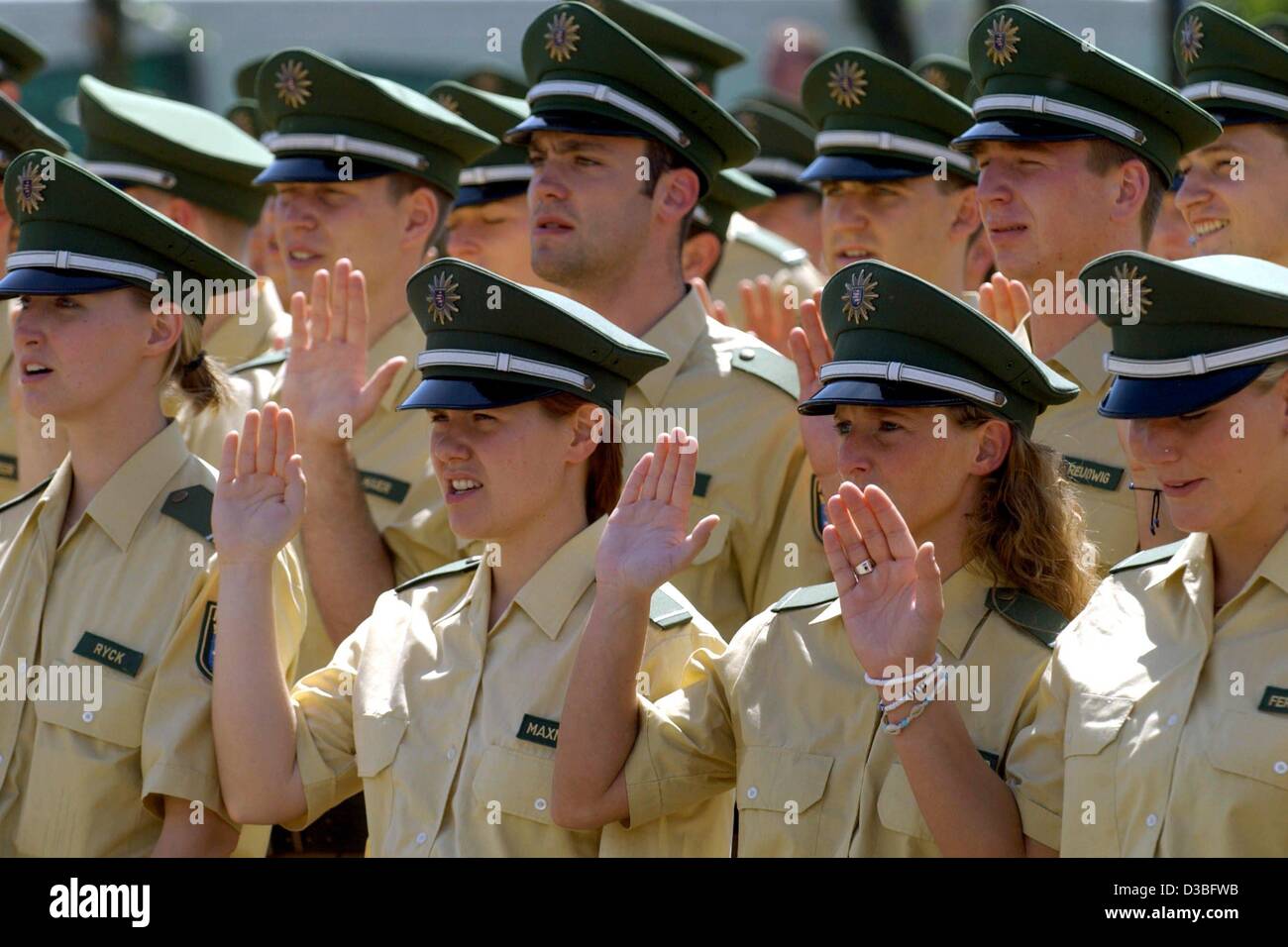 (Dpa) - eine Gruppe von jungen Polizisten erhöhen ihre Rechte Hand während ihre offiziellen Eid Zeremonie in Mülheim, Deutschland, 24. Mai 2003. Rund 620 Männer und Frauen angenommen ein Büro nach den Eid. Stockfoto