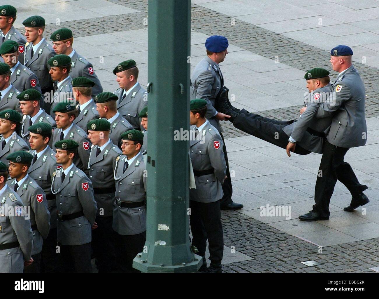 (Dpa) - zwei deutsche Soldaten entführen eine unbewusste Kameraden von einer Bildung Parade während der feierlichen öffentlichen Versprechen und Tattoo von Bundeswehr-Rekruten vor des Rathauses in Hamburg, Deutschland, 16. Juni 2003.  Es ist das erste Mal in 25 Jahren, die sich Soldaten öffentlich einen Eid in verpflichten Stockfoto