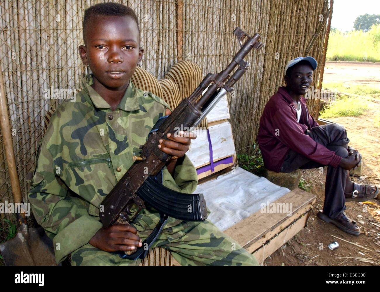 (Dpa) - ein Kindersoldat der Union der kongolesischen Patrioten (UPC) steht Wache und hält eine Gewehr in seinen Händen in Bunia, demokratische Republik Kongo, 19. Juni 2003. Laut UNICEF sind rund 10.000 Kinder als Soldaten in der geritten-Krisenregion in Nord-Ost-Kongo missbraucht. Stockfoto