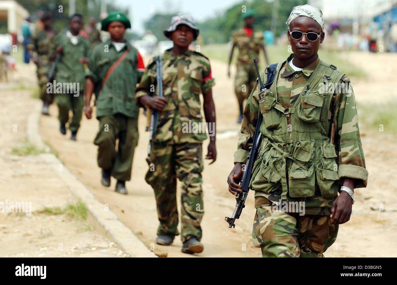 (Dpa) - eine Spalte von Hema Milizionär, die Mitglieder der Union der kongolesischen Patrioten (UPC), sind gekleidet in Kampfuniform und patrouillieren die Straßen von Bunia, demokratische Republik Kongo, 17. Juni 2003. Zwei Milizsoldaten wurden zum ersten Mal seit der Ankunft der Internationa durch französische Truppen erschossen. Stockfoto