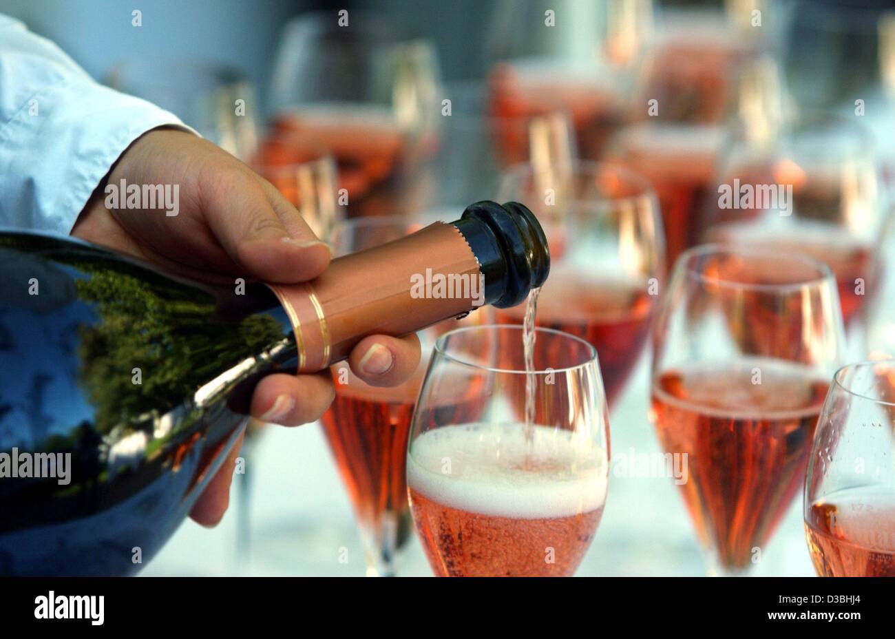 (Dpa) - ein Kellner füllt Gläser Champagner der französischen Marke "Ruinart" während der "Hutparty" für einen guten Zweck veranstaltet von Society-Lady Ulla Klingbeil in Berlin, 30. Mai 2003. Stockfoto