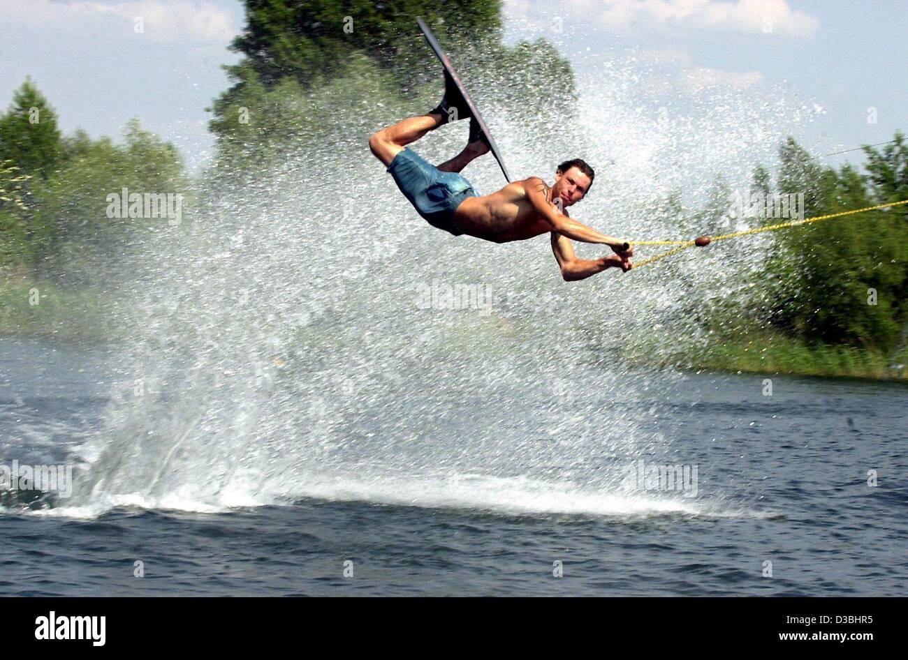 (Dpa) - deutsche Wasserskifahrer, David Koch, fliegt durch ihre auf seine Wasserski am See Neustaedt bei sommerlichen Temperaturen in der Nähe von Magdeburg, Deutschland, 2. Juni 2003. Ein paar Jahre Freizeit Seakers wurden für das letzte den Wasserski-Lift zu benutzen, der hat eine Länge von etwa 1.000 Metern. Stockfoto