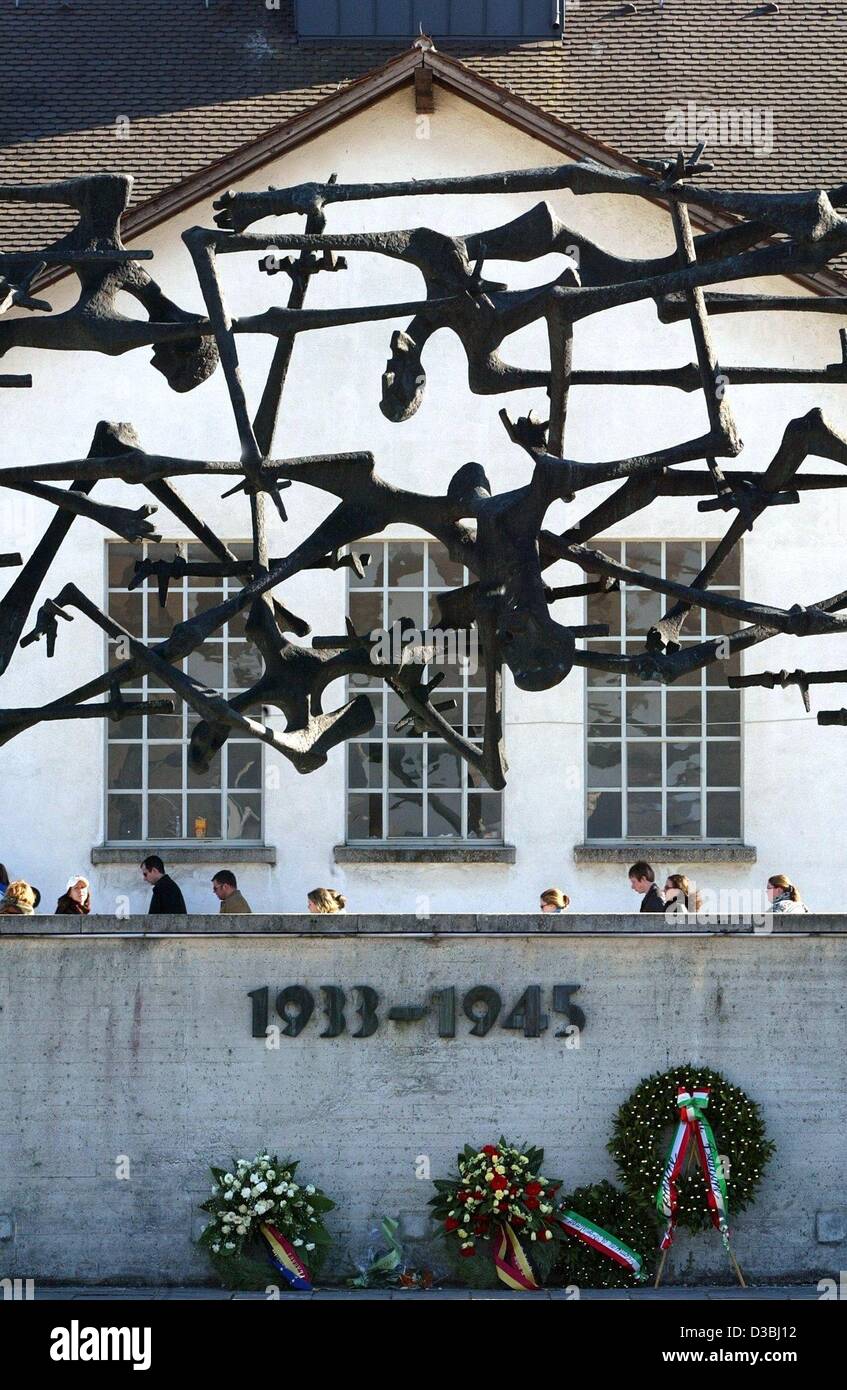 (Dpa) - liegen Kränze unter ein symbolischer Zaun, karg und schreiende menschliche Figuren in das ehemalige Konzentrationslager in Dachau, Deutschland, 22. März 2003 aus. Vor 70 Jahren am 22. März 1933 gegründet, wurde nur wenige Wochen, nachdem Hitler an die macht, gekommen war das erste nationalsozialistische Konzentrationslager Dachau. Heute D Stockfoto