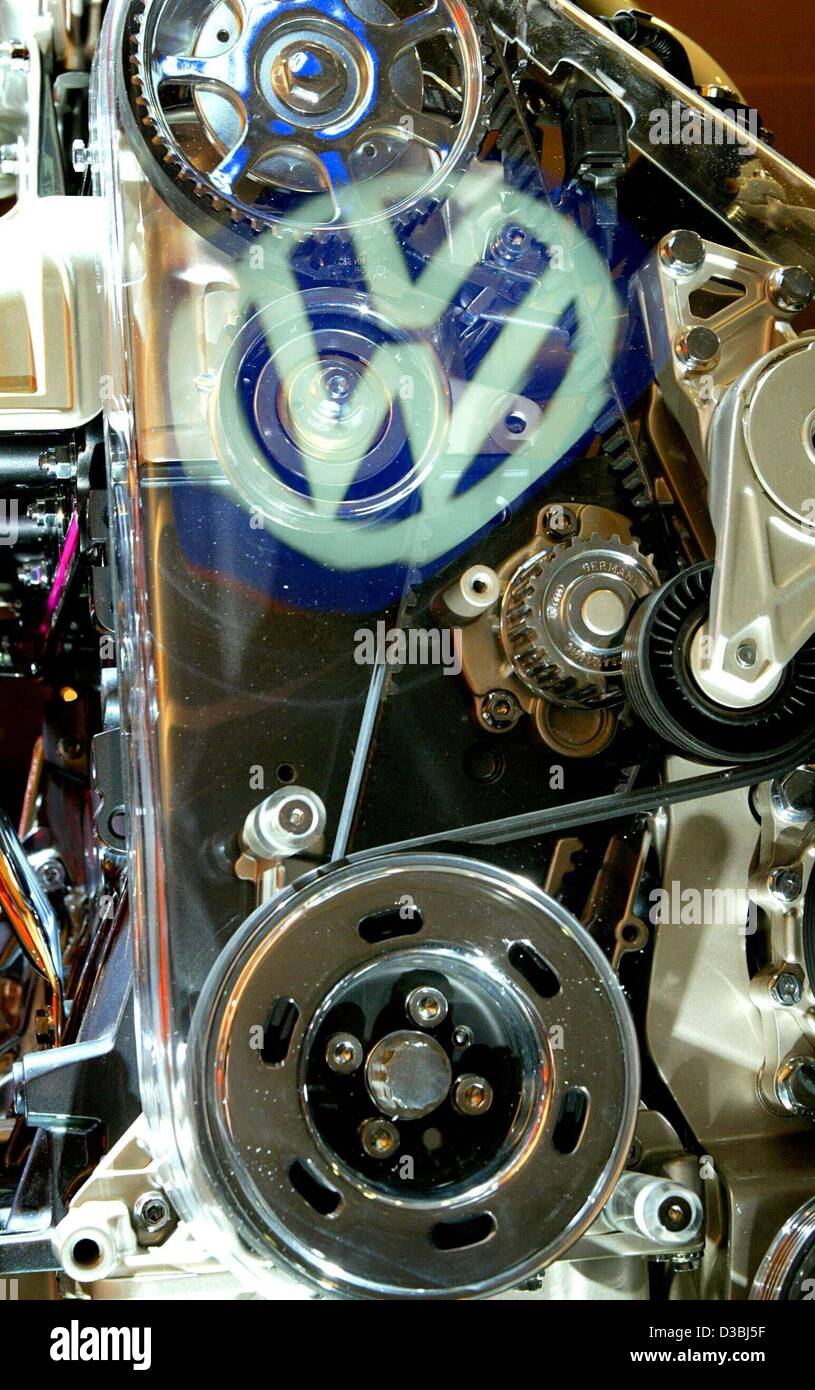 (Dpa) - das Logo der deutschen Volkswagen (VW) Automobilhersteller spiegelt sich auf die Glasabdeckung eines VW New Beetle-Motor, während der VW Hauptversammlung in Hamburg, Deutschland, 24. April 2003. Die deutsche Automobilindustrie Riese wird eine langsame Start im Jahr 2003 und ist für die sh fallen werden die Betriebsergebnisse Verstrebungen Stockfoto