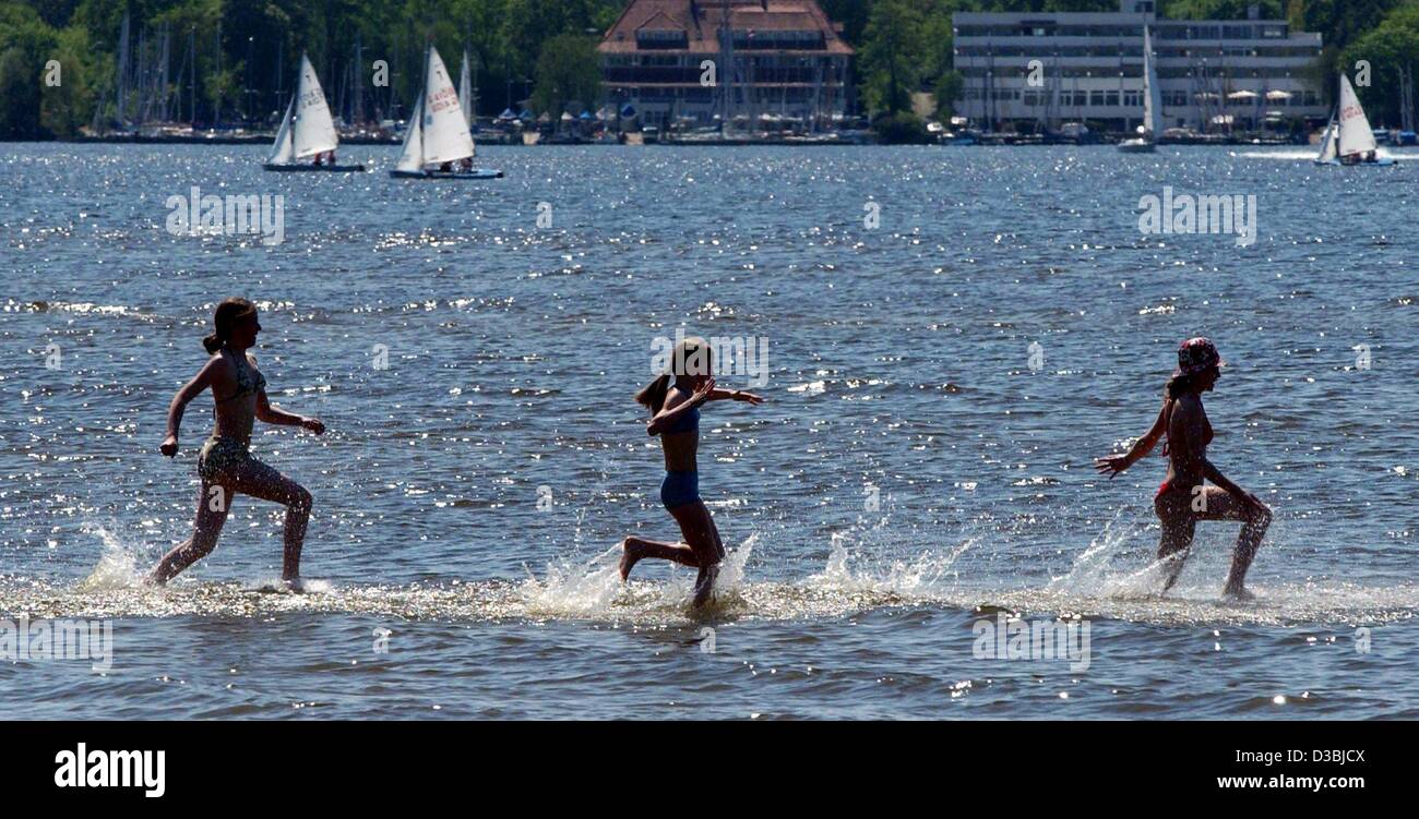 (Dpa) - drei junge Mädchen nehmen die Chancen und laufen Spritzwasser durch See am See Wannsee in Berlin, 5. Mai 2003. Stockfoto