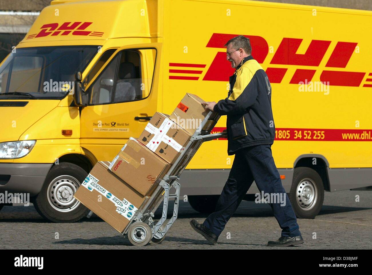 (Dpa) - Parzellen ein Mitarbeiter von DHL Worldwide Express drückt auf die Lieferung in Düsseldorf, 24. März 2003. DHL ist eine Tochtergesellschaft der Deutschen Post. Im Zuge der Restrukturierung von Prozessen bietet Deutsche Post World Net Paket-, Express- und Logistik-Dienstleistungen weltweit unter den stand Stockfoto