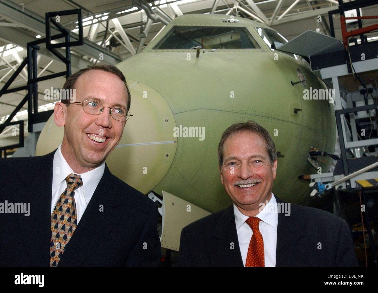 (Dpa) - Ben Bartel (L), CEO der US-Flugzeughersteller AvCraft und Wolfgang Walter, Geschäftsführer, stehen gemeinsam vor einer rohen Schale eines Jets der 328-Serie in der Montagehalle von Fairchild Dornier, der Flugzeughersteller in Oberpfaffenhofen in München, 26. März 2003 Stockfoto