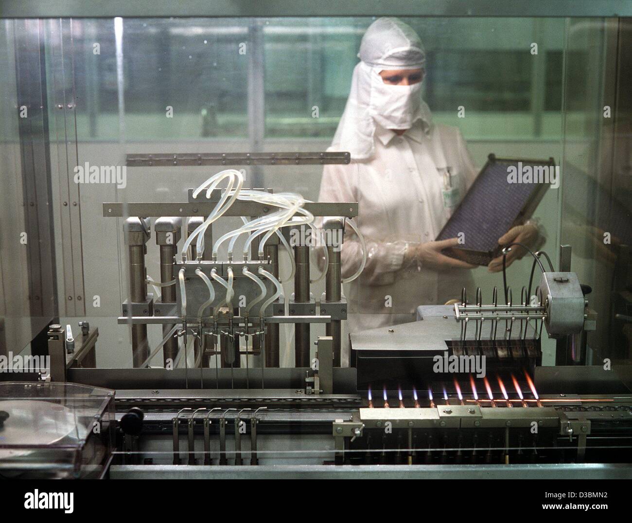 (Dpa) - Angestellter, gekleidet in Schutzkleidung, steht vor einer Installation die Impfstoffe im Labor der Behringwerke, Pharma-Unternehmen in Marburg, Deutschland (undatiert Filer) produziert. Stockfoto