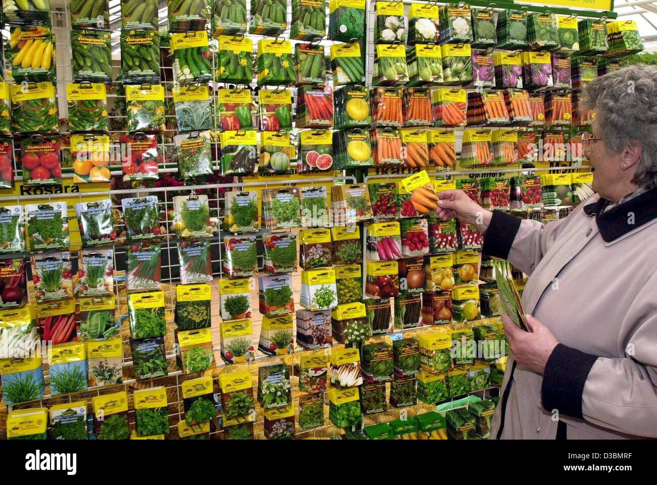 (Dpa) - eine Frau nimmt einen Beutel mit Samen aus einem Regal von verschiedenen Gemüse-Saatgut in ein Gartencenter in Stralsund, Norddeutschland, 28. März 2003. Es ist Frühling und Hobbygärtner beginnen zu säen und wachsen Blumen und Gemüse. In Deutschland kaufen immer mehr Hobbygärtner ihre Samen und Pflanzen Stockfoto