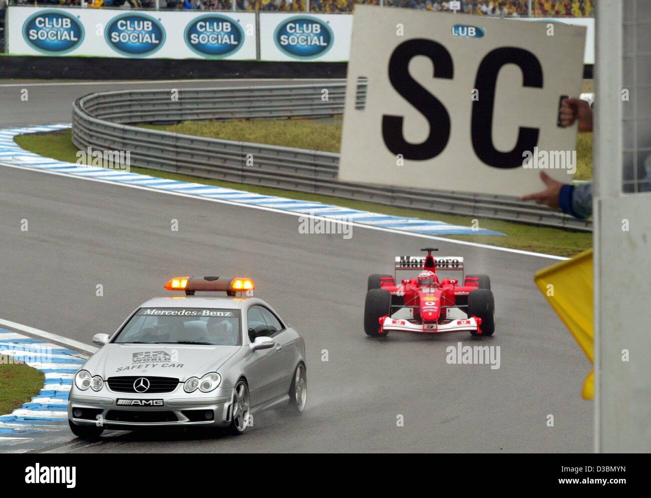 (Dpa) - treibt das Safety-Car durch die erste Kurve, gefolgt von brasilianischen Formel 1 pilot Rubens Barrichello in seinem Ferrari in der Formel 1 Rennen auf der Rennstrecke von Interlagos in Sao Paulo, Brasilien, 6. April 2003. Das Rennen wurde durch eine Safety-Car viermal unterbrochen. Aufgrund von starken Regenfällen Stockfoto