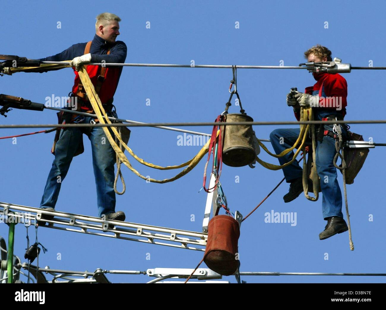 (Dpa) - zwei Arbeiter sind hoch oben auf einem Strommast auf die interurban Stromzuführungen in Meerbusch, Deutschland, 19. März 2003 arbeiten. Im Vergleich zu anderen EU-Ländern bleibt Strom teuer für private Kunden in Deutschland. Laut dem statistischen Amt Eurostat in Brüssel, die Preise für Stockfoto