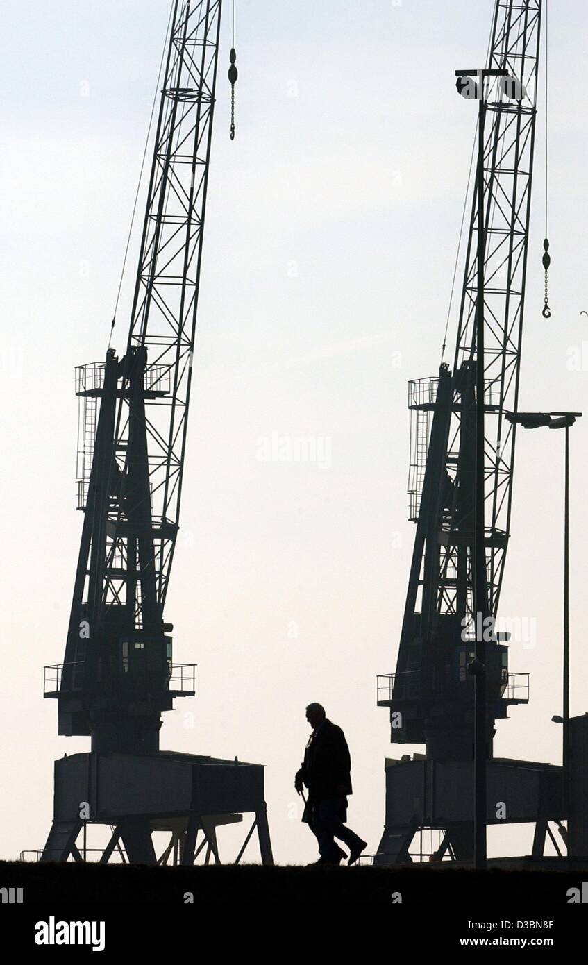 (Dpa) - ein Mann geht zwei Kräne im Hafen von Bremerhaven, Deutschland, 16. März 2003. Stockfoto