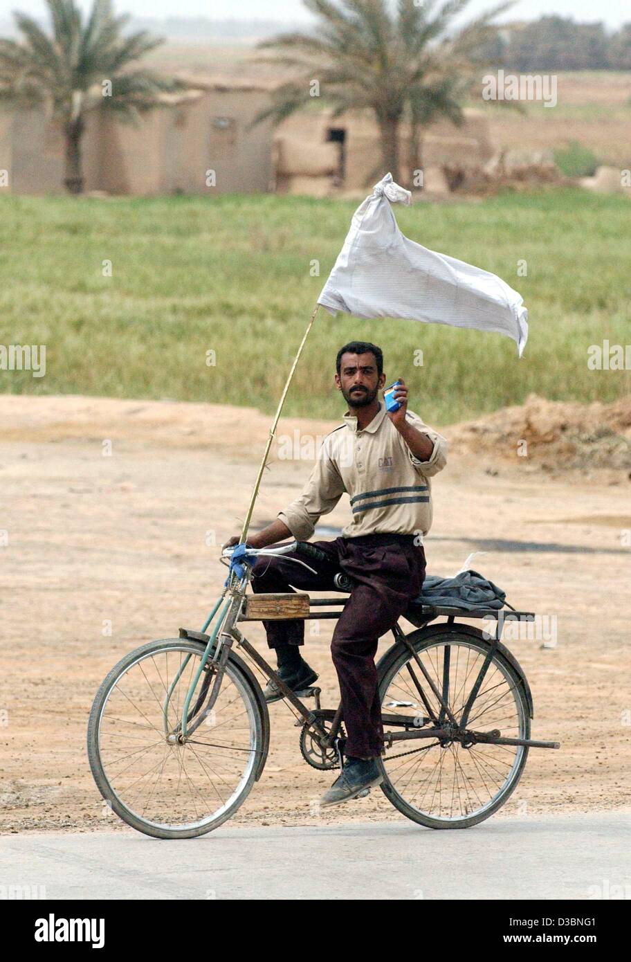 (Dpa) - Zyklen ein irakischen Zivilisten mit einer weißen Fahne in südlicher Richtung in der Nähe von Al Aziziyan ca. 40 km südlich von Bagdad, Irak, 4. April 2003. Die Koalitionskräfte sind in Richtung der irakischen Hauptstadt, während der Luftangriffe auf die Hauptstadt und anderen Städten weiter. Stockfoto