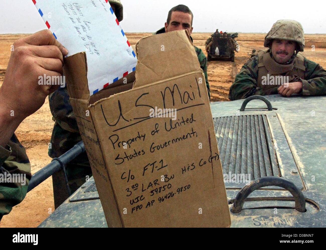 (Dpa) - zieht die Hand eines Space-Marines einen Brief von einem Karton welche Funktionen als ein Briefkasten in der Nähe von Ad Dianiyah im Südirak, 31. März 2003. US-Marines den 3. Licht Amoured Reconnaissance Battalion (3. LAR) ihre e-Mails empfangen. US-Truppen treffen immer noch erbitterten Widerstand während ihrer voraus und Rück Stockfoto