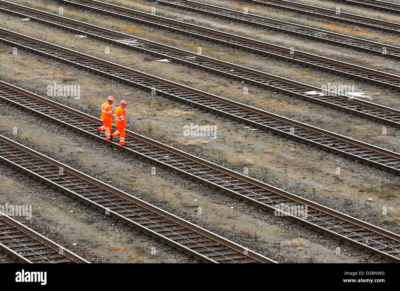 (Dpa) - zwei Mitarbeiter der DB (Deutschen Bahn AG) Traverse verfolgt von einem Rangierbahnhof in München, Deutschland, 12. März 2003. Die Deutsche Bahn AG ist wegen seiner umstrittenen Preissystem mit Druck beaufschlagt. Laut der deutschen Zeitschrift "Spiegel" (Spiegel), das Geschäftsvolumen des deutschen Stockfoto