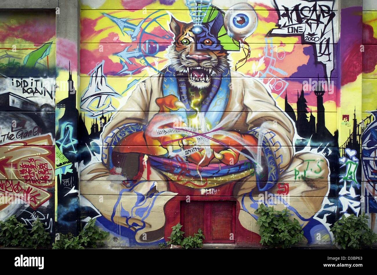 (Dpa) - ein Blick auf eine opulente Wandmalerei, die die Karikatur eines Tigers zeigt gekleidet in ein weißes Gewand sitzen über eine Eingangstür an einer Wand in Wiesbaden, Deutschland, 1. Juli 2003. Das Wort "Graffiti" stammt von dem griechischen Wort "Graphein", was schreiben bedeutet. Der Begriff durch den italienischen l geändert Stockfoto