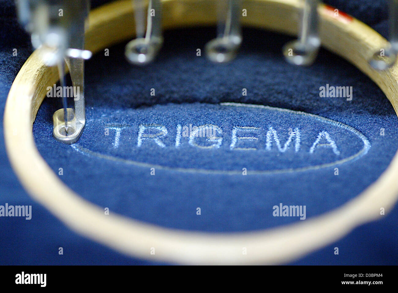 (Dpa) - die Nadel einer Nähmaschine näht das Logo T-shirt und Tennis Bekleidung Hersteller Trigema in ein Kleidungsstück in Burladingen, Deutschland, 16. Dezember 2004. Trigema mit ca. 1.200 Mitarbeitern fertigt die Gewinne für die letzten 35 Jahre. Geschäftsführer Wolfgang Grupp nahm t Stockfoto