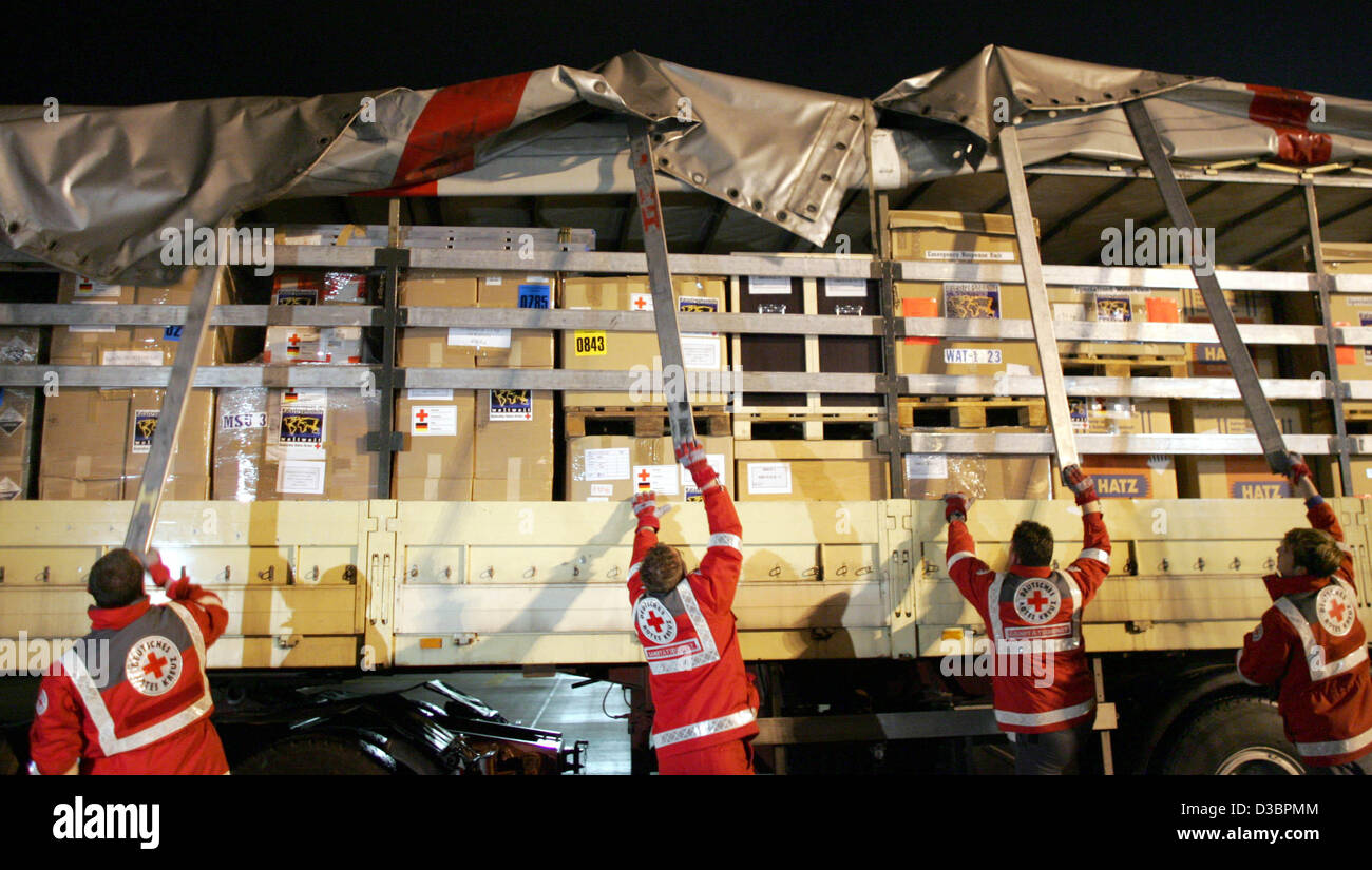 (Dpa) - Mitarbeiter des Deutschen Roten Kreuzes entladen ein LKW, die mit zwei mobilen Süßwasser Einheiten geladen wird, die am Flughafen Köln/Bonn, Deutschland, 29. Dezember 2004 disjunkt sind. Das Deutsche Rote Kreuz schickt zwei mobile Süßwasser-Einheiten bis zu 120.000 Liter unberührten produzieren können Stockfoto