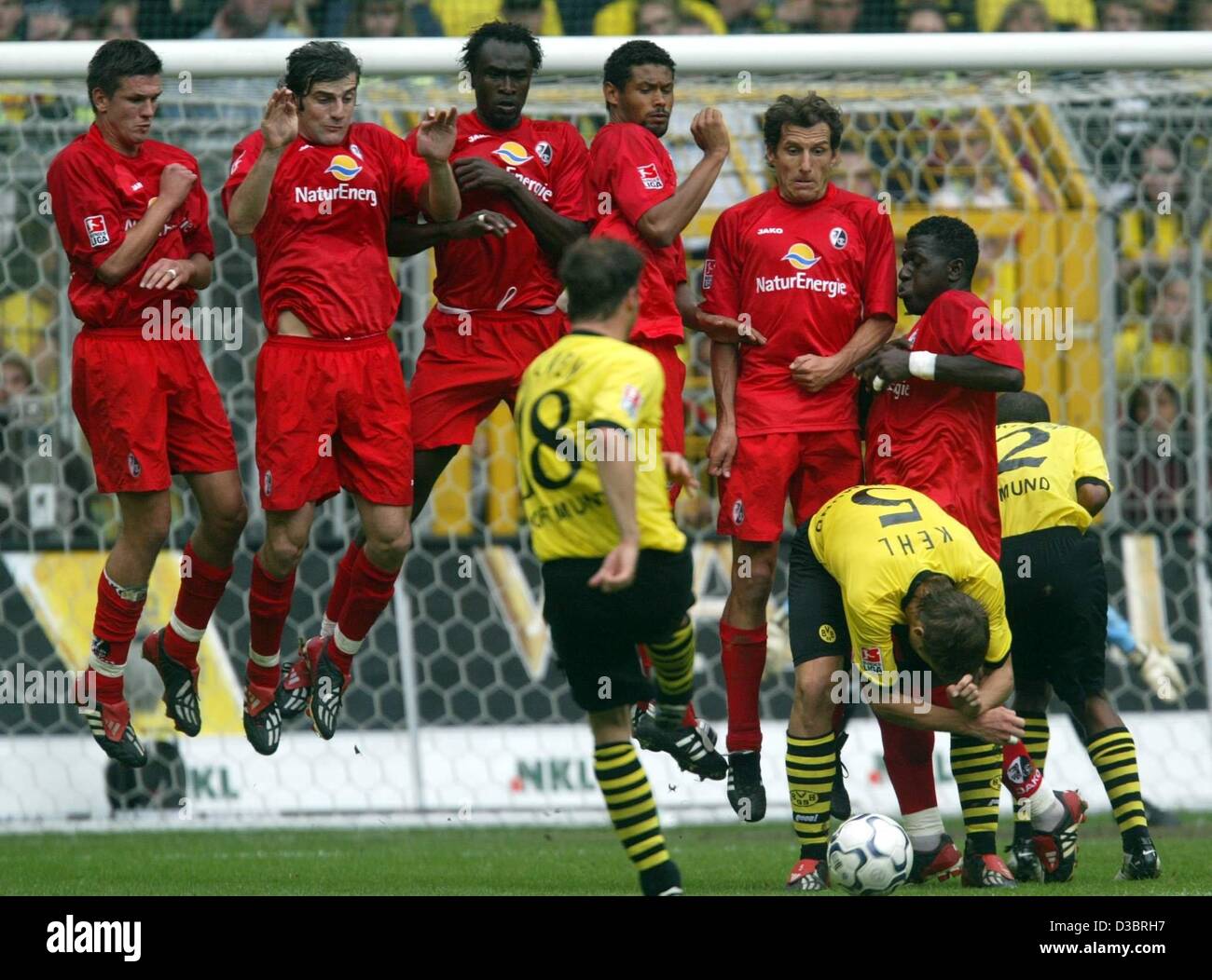 (Dpa) - der Dortmunder Mittelfeldspieler Lars Ricken (C, Front, Nr. 8) kickt den Ball bei einem Freistoß an der Mauer der Freiburger Fußball-Spieler während der Dortmunder Verteidiger Sebastian Kehl vorbei (2. v. R, Nr. 5) und Dortmund, Giuseppe Reina (R, Nr. 2) klar der Weg in die Bundesliga Fußballspiel Borussia Dor nach vorn Stockfoto