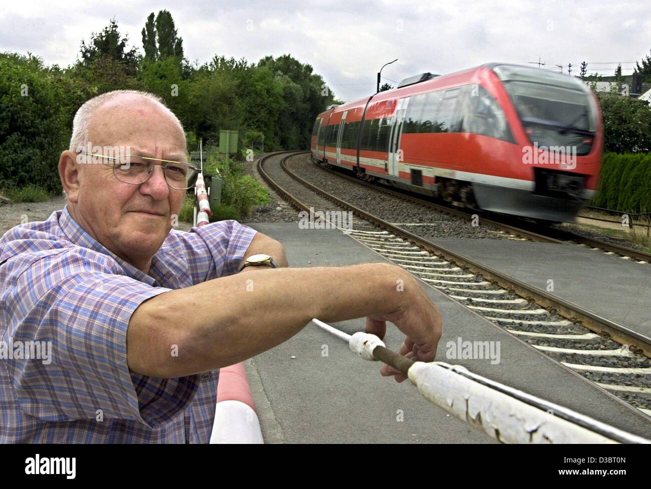 (Dpa) - Wolfgang Schmitt, Torhüter der deutschen Eisenbahngesellschaft Deutsche Bahn stellt an einem Eisenbahn-Tor in Münster-Sarmsheim bei Bingen, Deutschland, 27. August 2003. Der Beruf des Gatekeeper wird mehr und mehr durch moderne Technik ersetzt. Stockfoto