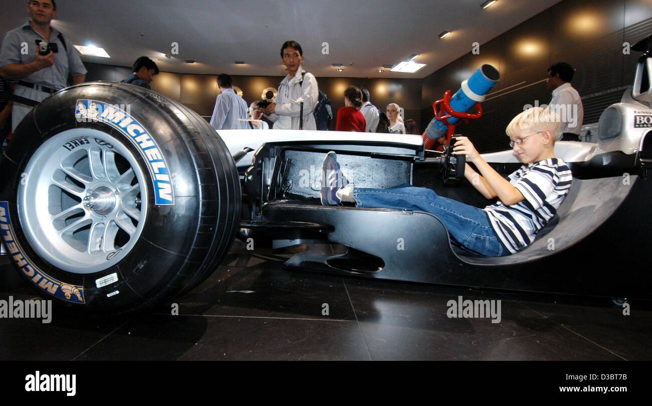 (Dpa) - sitzt ein kleiner Junge in einen Formel 1 Rennwagen, der entlang der Rollachse des Autos am Stand für sportliche Autos von Daimler-Chrysler auf der internationalen Auto Show IAA in Frankfurt am Main, 12. September 2003 aufgeschnitten ist. Von 12 September bis 21 September die Messe mit rund 1.000 Exhibitione Stockfoto