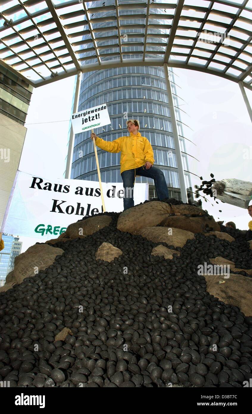 (Dpa) - eine Greenpeace-Aktivist steht auf einem Berg von Kohle und hat einen Beitrag in der Hand die "Änderung Energie, jetzt!" vor dem Hauptsitz der deutschen Energie liest Riese RWE in Essen, Deutschland, 17. September 2003. Greenpeace sammelten für beenden die Braunkohle Energiewirtschaft und dema Stockfoto