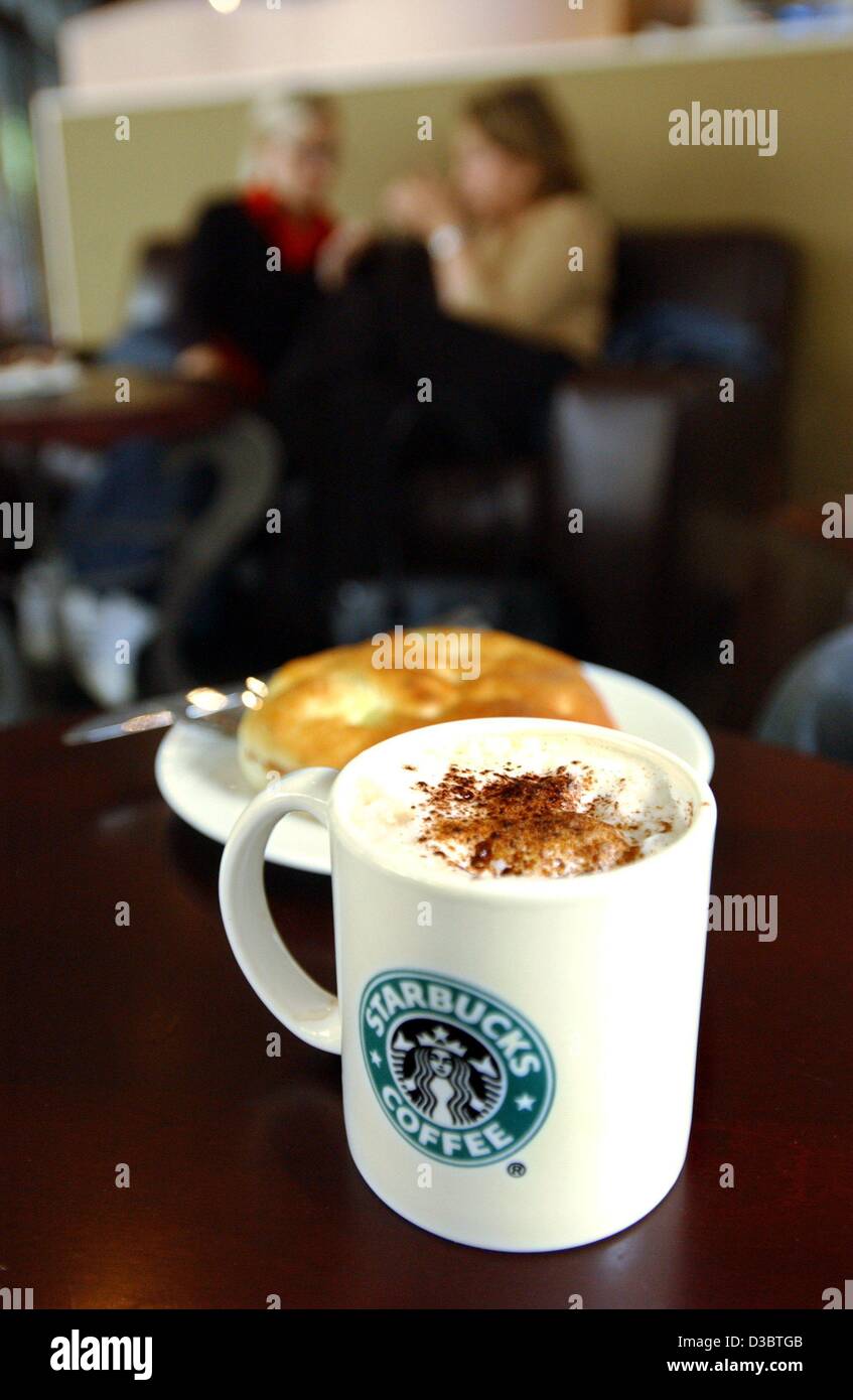 (Dpa) - eine Tasse Starbucks Cappuccino ist vor einem Teller mit einem Kuchen in einem Café der Starbucks-Kaffee-Kette in Köln, 14. Juni 2003 gesehen. Im Vergleich zu anderen Cafés Starbucks bietet eine größere Auswahl an Kaffees, aber die Preise sind höher als die durchschnittliche Cafés: ein Café au Lait kostet Stockfoto