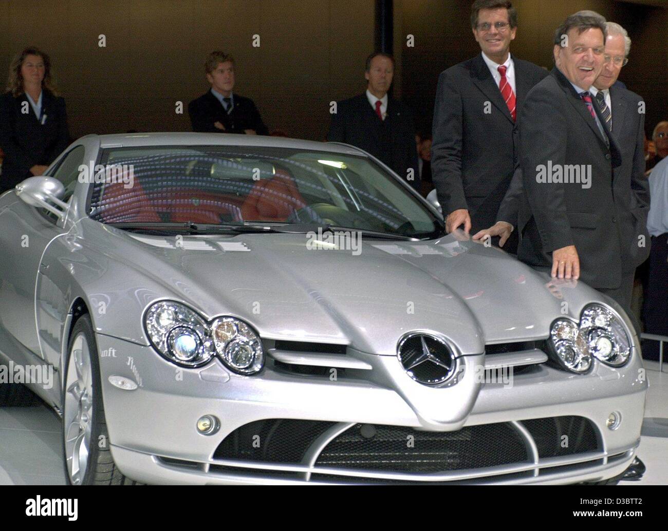 (Dpa) - steht German Chancellor Gerhard Schroeder (R) neben einem Mercedes SLR McLaren bei der offiziellen Eröffnung der internationalen Auto Ausstellung (IAA) in Frankfurt am Main, 11. September 2003. Im Hintergrund rechts Juergen Hubbert CEO von Mercedes und im Hintergrund links der Schroeder Bernd Gottschalk ( Stockfoto