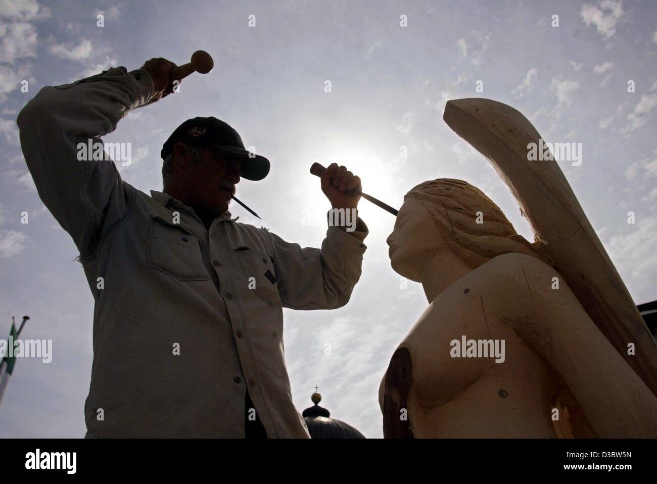 (Dpa) - italienischer Bildhauer Gustavo Miracolo arbeiten auf einem hölzernen Engel Skulptur für einen Bildhauer-Wettbewerb in St. Blasien, Deutschland, 5. September 2003. 19 Bildhauer aus zehn verschiedenen Nationen nehmen Teil an dem Wettbewerb mit dem Thema "Engel". Stockfoto