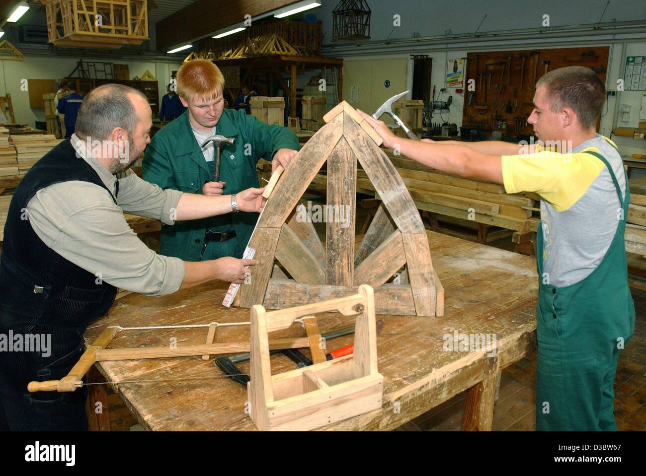 (Dpa) - erklärt Kursleiter Harry Nowak Auszubildende Stephan Kathner (R, 17) und Bjoern Busak (C, 16), die das Handwerk eines Bauarbeiters Stahlbeton, den Bau eines Gehäuses im Ausbildungszentrum der Bauindustrie in Frankfurt Oder, Ostdeutschland, 27. August 2003 zu erlernen. Ich Stockfoto