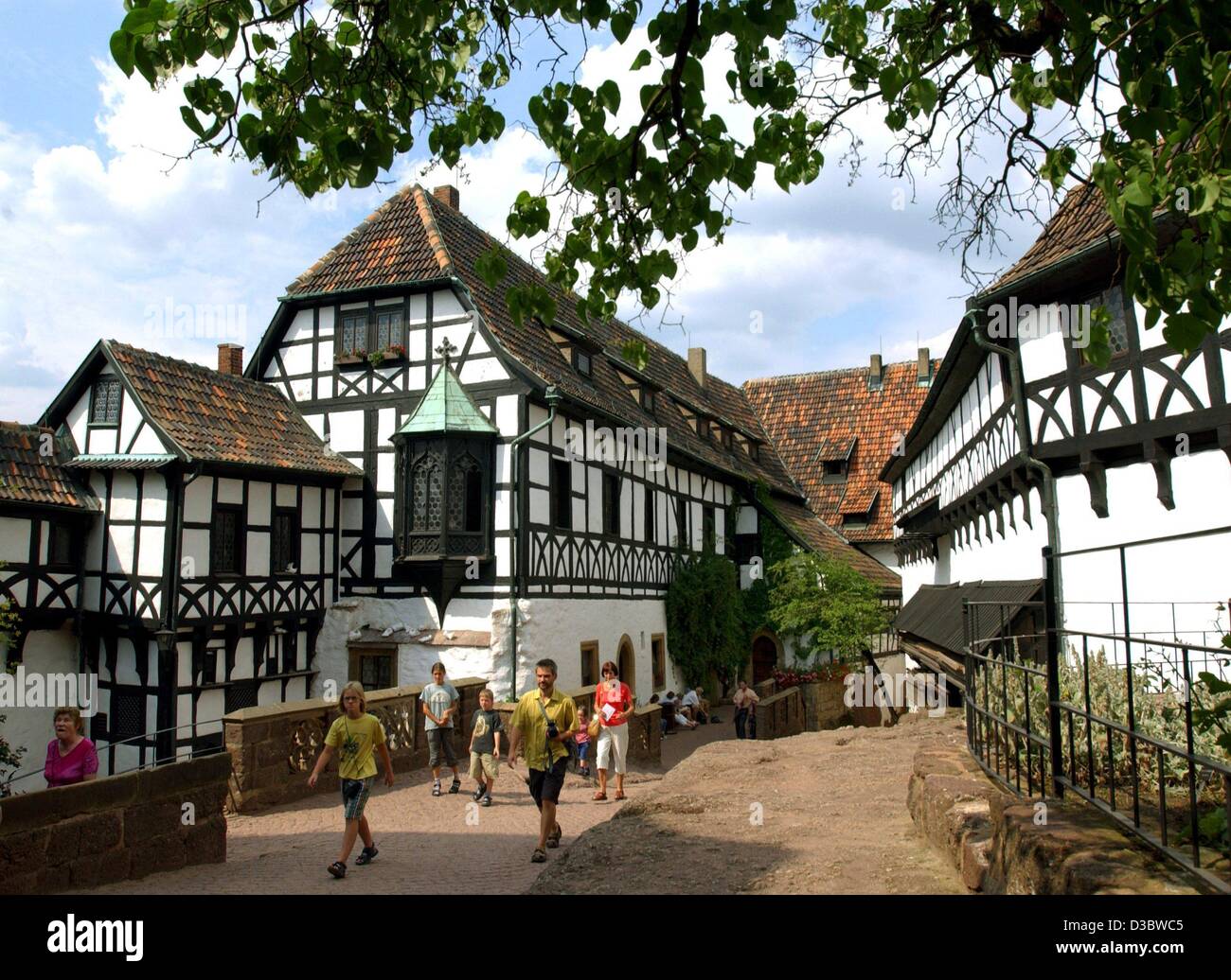 (Dpa) - Touristen besuchen die Wartburg befindet sich über der Stadt Eisenach, Deutschland, 30. Juli 2003. Obwohl die Wartburg einige ursprüngliche Abschnitte aus der Feudalzeit bewahrt hat, erworben seiner Form während des 19. Jahrhunderts Rekonstitution. Es war während seines Exils auf der Wartburg, dass Martin Luth Stockfoto