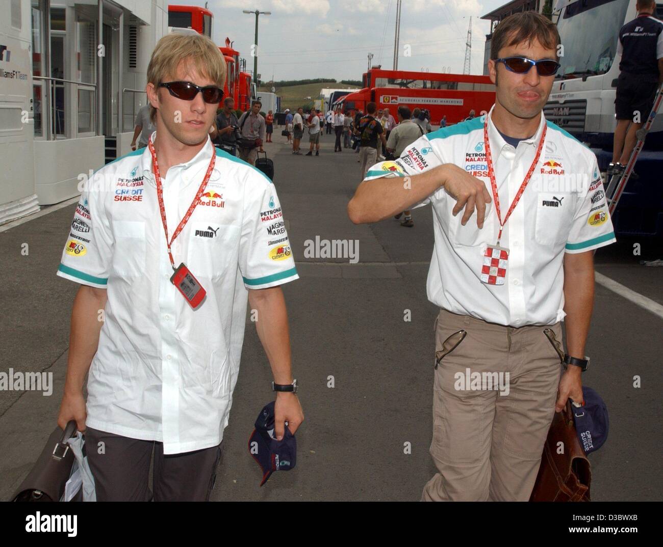 (Dpa) - die beiden deutschen Formel 1 Piloten Nick Heidfeld (L) und Heinz-Harald Frentzen, sowohl des Schweizer Sauber Teams, überqueren den Fahrerbereich auf der Rennstrecke Hungaroring in der Nähe von Budapest, Ungarn, 22. August 2003. Sauber hat angekündigt, dass es italienische Giancarlo Fisichella (Jordan-Ford) rekrutiert hat Stockfoto