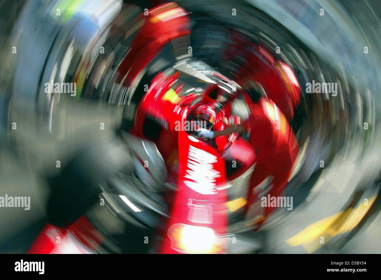 (Dpa) - das Spin-Effekt Foto zeigt Weltmeister und aktuellen Gesamtführenden, deutscher Formel-1 pilot Michael Schumacher in seinem Ferrari-Rennwagen zurückgedrängt in die Grube nach dem freien Training auf der Rennstrecke von Hockenheim, Deutschland, 1. August 2003. Schumacher beendete mit der elften beste ti Stockfoto