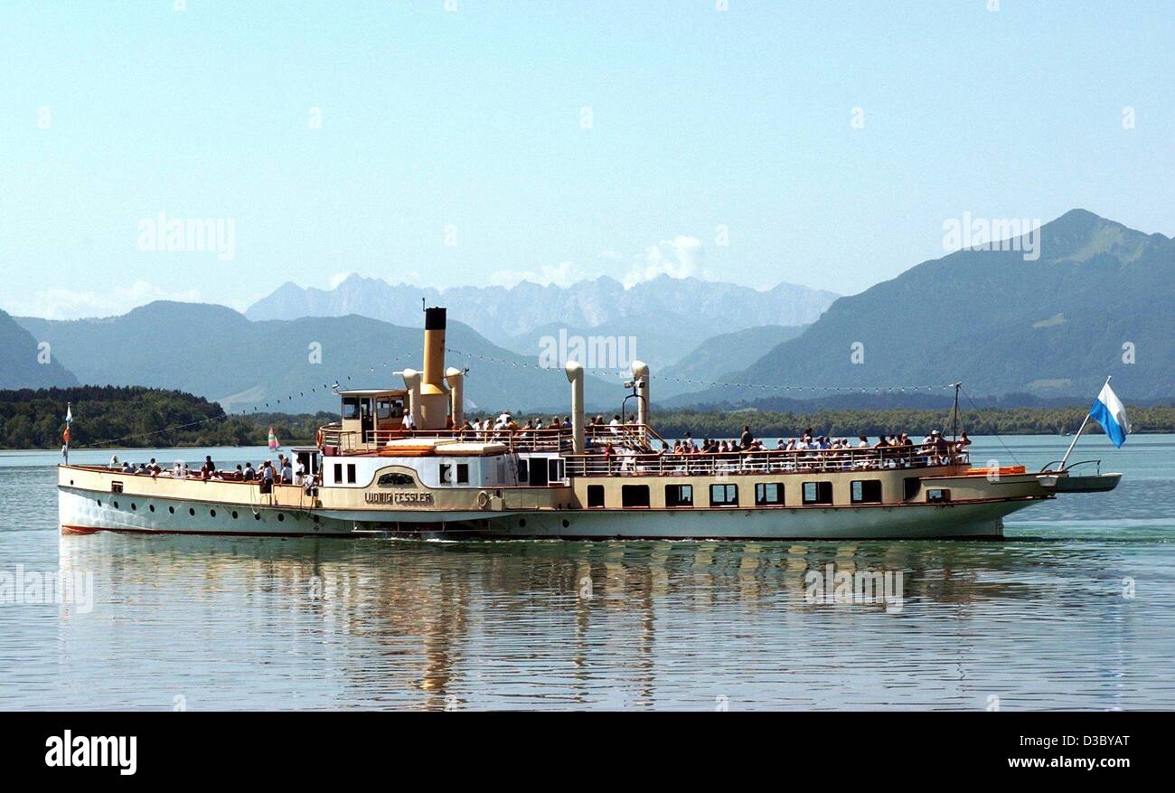 (Dpa) - vor dem Panorama der Tiroler Alpen der Raddampfer "Ludwig Fessler" über See Chiemsee in der Nähe von Chieming, Deutschland, 22. Juli 2003 steuert. Der Raddampfer ist das älteste Schiff auf das "Bayerische Meer". Stockfoto