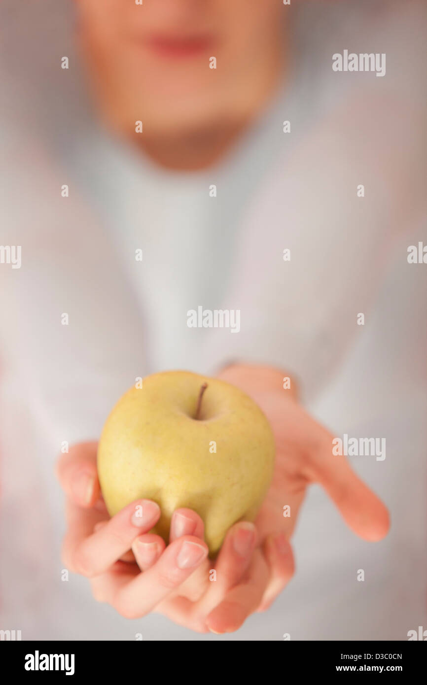 Frau hält einen Apfel Stockfoto